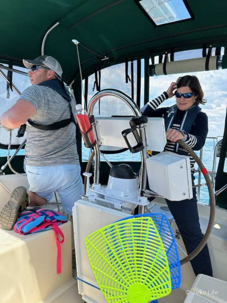 action shot Kara at the helm and Kyle raising the sails