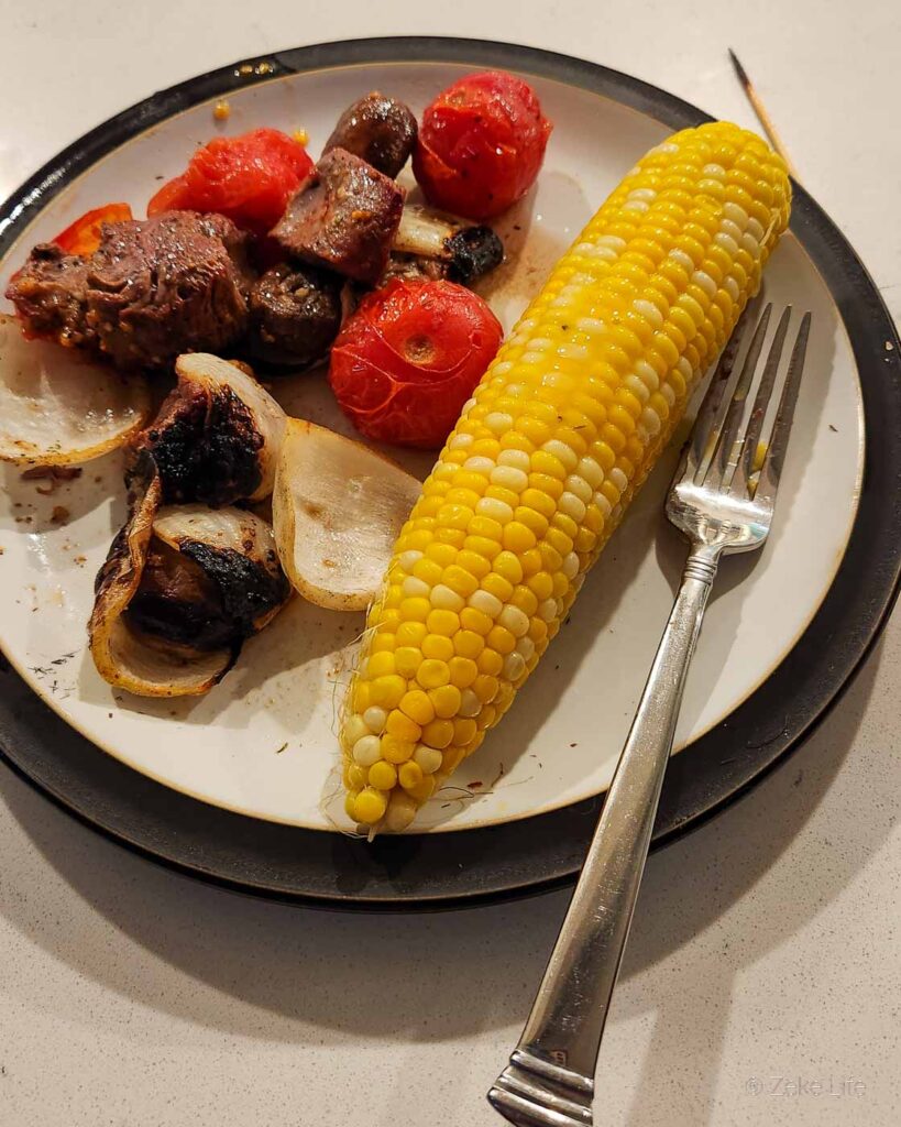 cooked steak kabobs with corn-on-the-cob